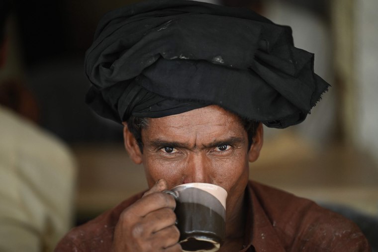 Image: A man drinks a cup of tea at a roadside restaurant in Islamabad, Pakistan, on June 15, 2022.