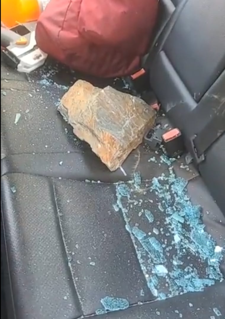 A large stone with sharp edges in the back seat of the car.