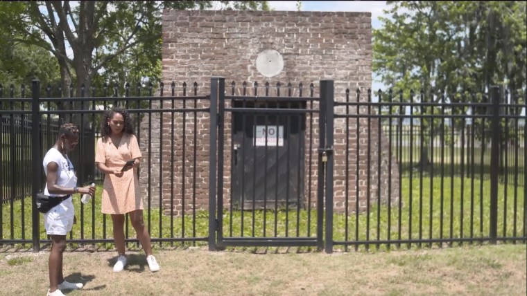 Akua Page and Maya Eaglin pour libations in front of the the Dead House in Charleston, S.C.