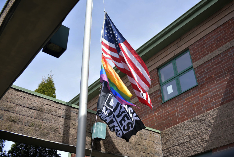 The American flag, Pride flag and Black Lives Matter flag fly