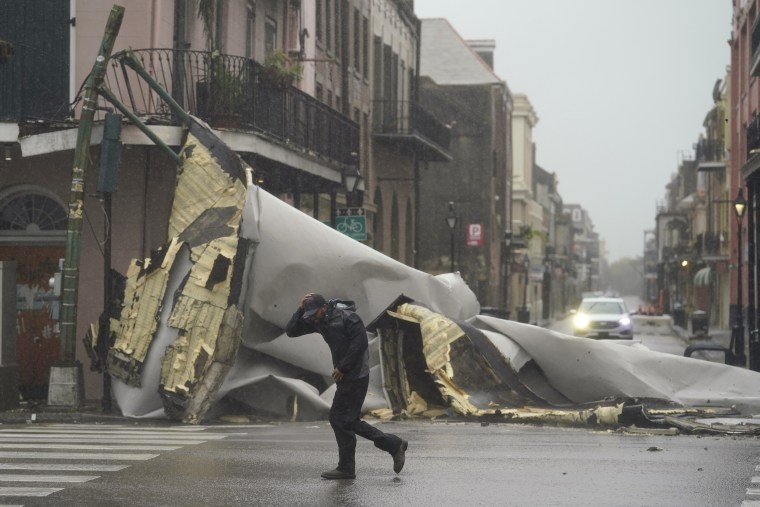 A man passes by a section of roof that was blown off of a building in the French Quarter by Hurricane Ida winds, on Aug. 29 in New Orleans.