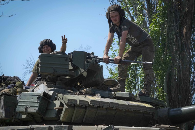 Soldiers sit atop a tank in the Donetsk region. To boost its war efforts, the government has banned men ages 18 to 60 from leaving the country in case it needs to start a draft.