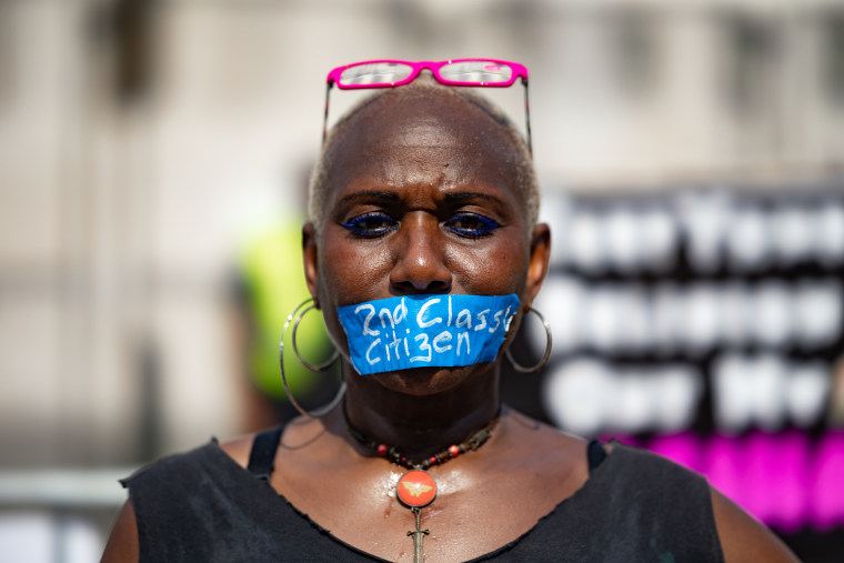 An abortion rights demonstrator with a "2nd Class Citizen" sticker covering her mouth outside the Supreme Court in June  2022.