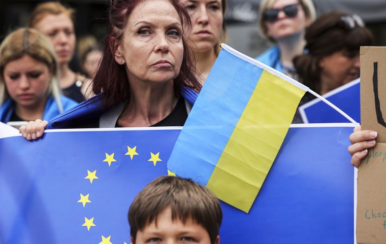 Image: A protestor holds an EU and Ukrainian flag during a demonstration in support of Ukraine outside of an EU summit in Brussels, on June 23, 2022.