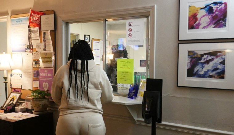 A woman stands at the check-in window of the Hope Medical Group for Women