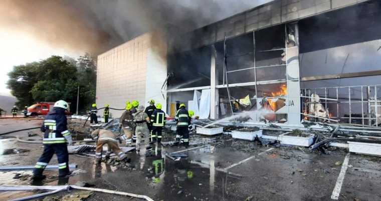 Firefighters put out the fire in a mall hit by a Russian missile strike