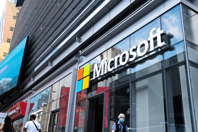 Pedestrians walk past a Microsoft Technology Center