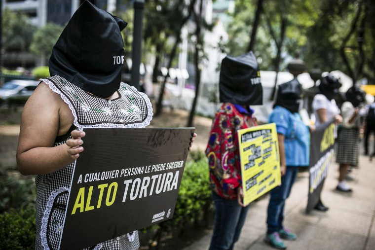 Image: Women of Amnesty International, hold a banner during the UN's International Day in Support of Victims of Torture  on June 26, 2015 in Mexico City.
