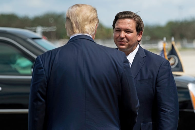Then President Donald Trump is greeted by Florida Gov. Ron DeSantis at the airport in Fort Myers on Oct. 16, 2020.