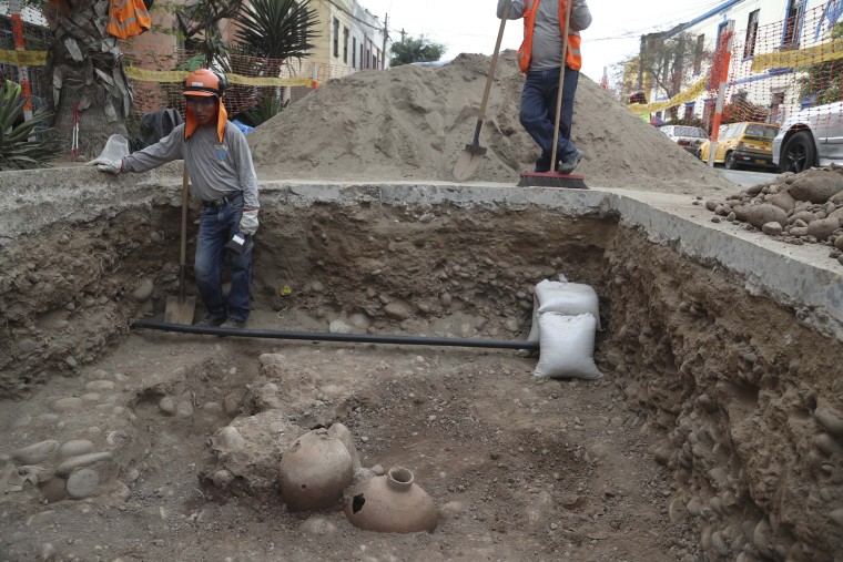  Gas workers stand by ancient bones and vessels from a previous Inca culture that they discovered while digging in the Brena neighborhood of Lima, Peru,  Feb. 11, 2020.