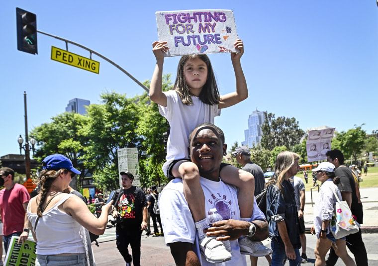 Protestor Justin Spencer with 7 year-old Mila Reveles of Los Angeles on his shoulders as they march through downtown as they protest the overturning of Roe v. Wade in Los Angeles on June 25, 2022.