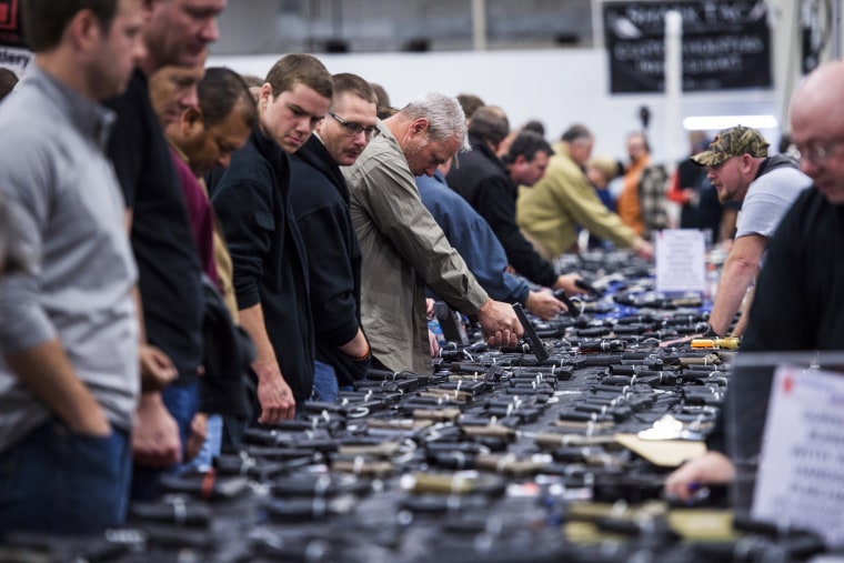 People look at handguns during The Nation's Gun Show in Chantilly, Va. on October 3, 2015.