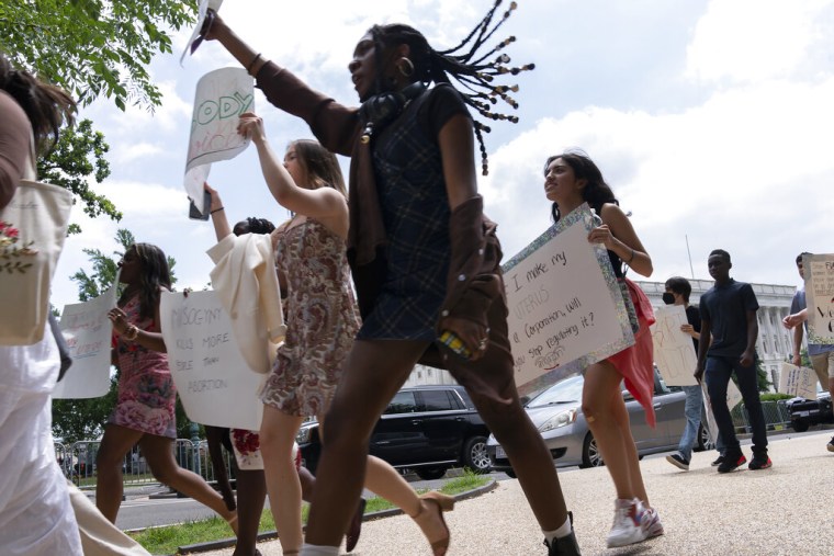 Un grupo de personas marchan con pancartas frente a la Corte Suprema para expresar su descontento con la decisión de la mayoría conservadora de revocar Roe v. Wade, el viernes 24 de junio de 2022.