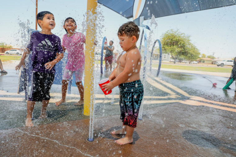 Los niños juegan en un parque acuático mientras la temperatura alcanza los 115 °F el 12 de junio de 2022 en Imperial, California.