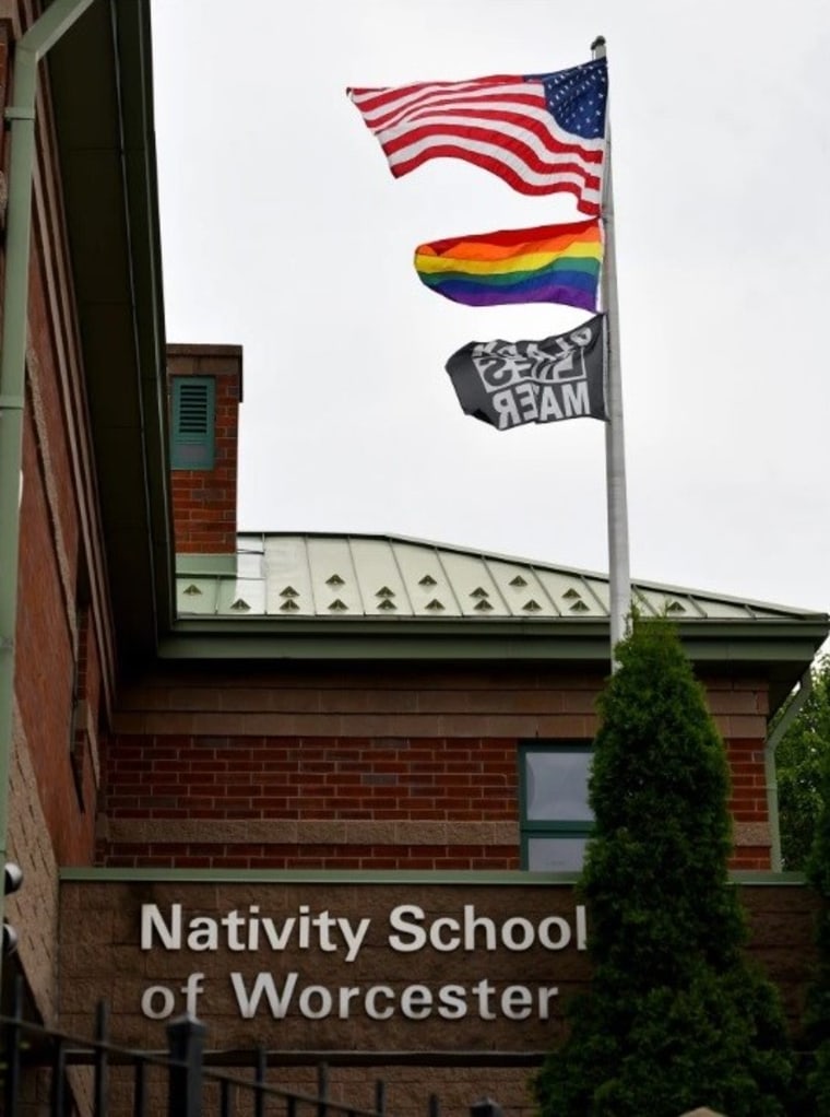 Una bandera estadounidense, una bandera del Orgullo y una bandera de Black Lives Matter ondean en un patio fuera de la Nativity School of Worcester en Worcester, Massachusetts.