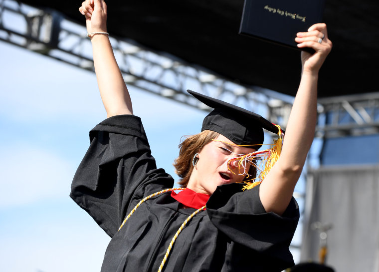 La graduada del Long Beach City College, Eva Luna Smith, aplaude tras recibir su diploma en Long Beach, el jueves 9 de junio de 2022.
