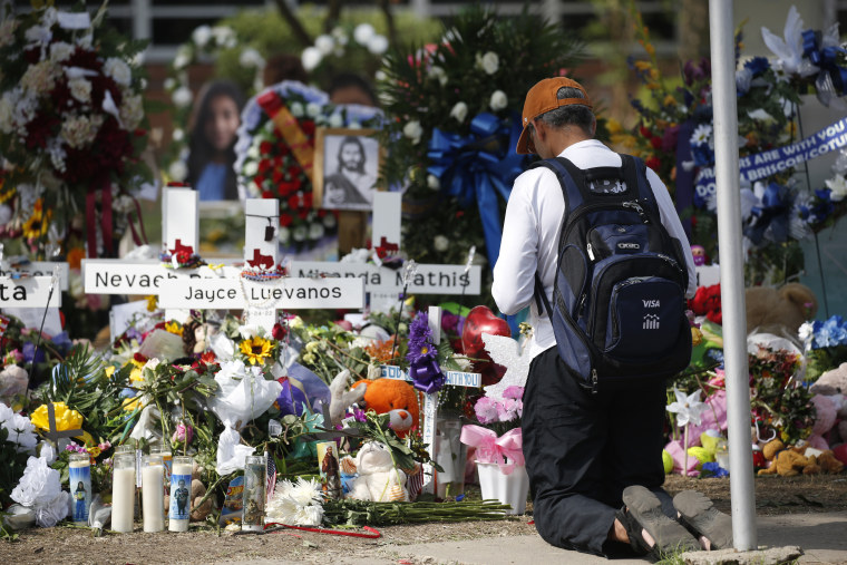 Un hombre se arrodilla en un memorial fuera de la Escuela Primaria Robb para honrar a las víctimas muertas en un tiroteo escolar en Uvalde, Texas, el domingo 29 de mayo de 2022.