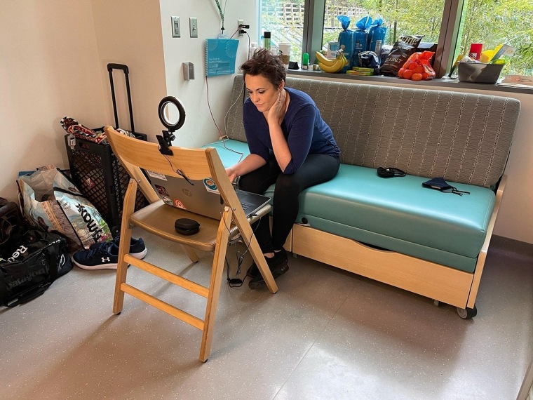 Whitney Stohr creates a space to work on her laptop in a room at Seattle Children's Hospital.