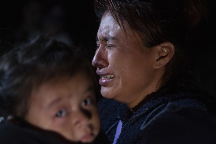 Una mujer de Guatemala llora mientras carga a su hijo después de haber sido contrabandeado a través del río Grande en Roma, Texas, el 30 de marzo de 2021.