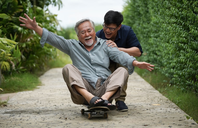 son helping dad on skateboard