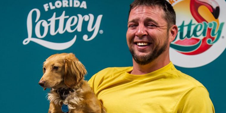 Leonard Linton holds his dog Ivy while claiming his massive lottery win.