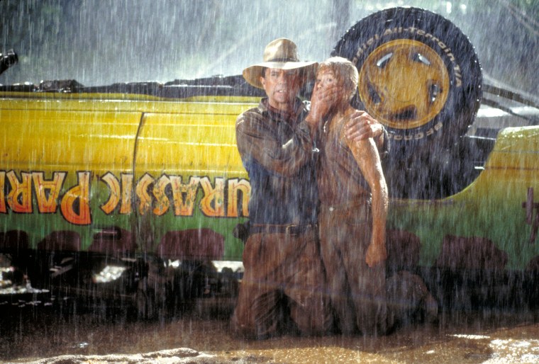 Actor Sam Neill as Dr. Alan Grant and Ariana Richards as Lex try to avoid the attention of a Tyrannosaurus Rex in a scene from the film "Jurassic Park." 