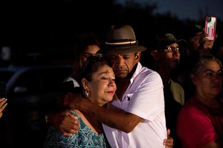 Christine y Michael Ybarra se abrazan en el lugar donde decenas de migrantes fueron encontrados muertos dentro de un camión de remolque en San Antonio, Texas, EE. UU. 27 de junio de 2022.