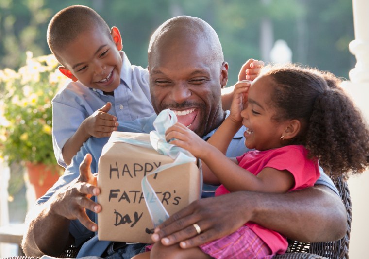 dad opening father's day gifts with kids on lap