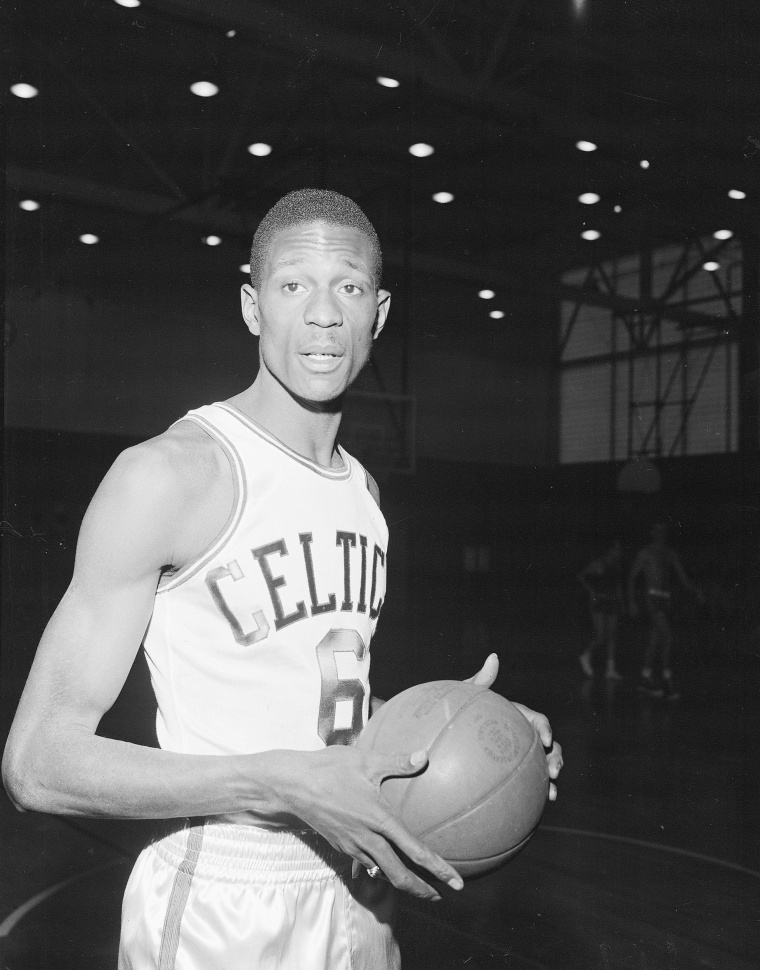 Bill Russell of San Francisco and the Olympic basketball team wears a Boston Celtics uniform for his first practice with the NBA team shortly after signing a contract in Boston on December 19, 1956.