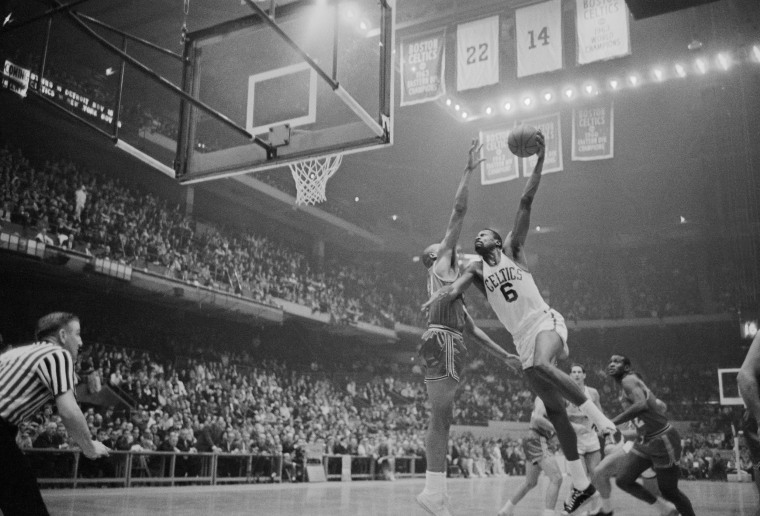 Boston Celtic's Bill Russell climbs high to score as St. Louis Hawk's Zelmo Beaty tries to block in 1963.