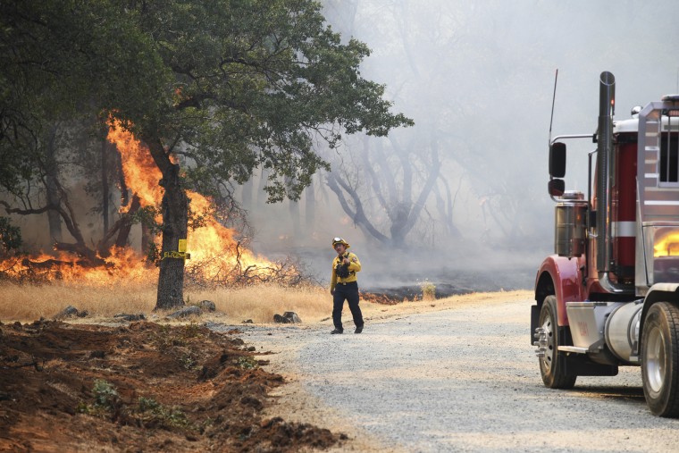 A firefighter assesses the approaching fire along Troost Trail in California's rural Nevada County on June 28, 2022.