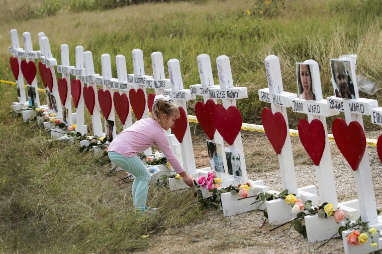 Image: Four-year-old Shaelyn Gisler leaves a flower at a memorial where 26 crosses were placed to honor the victims killed at the First Baptist Church of Sutherland Springs on November 9, 2017 in Sutherland Springs, Texas.