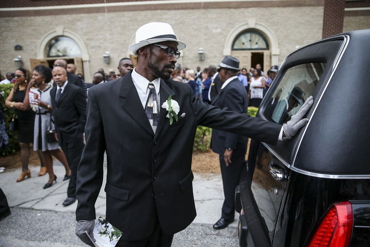 Image: A mourner touches the back of the hearse carrying the casket of Ethel Lance, 70, who was one of nine victims of a mass shooting at the Emanuel African Methodist Episcopal Church, on June 25, 2015 in North Charleston, S.C.