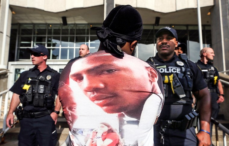 A protester stares down an Akron police officer outside the Harold K. Stubbs Justice Center during a protest on July 2, 2022, in Akron, Ohio, after Akron police officers shot and killed Jayland Walker earlier.