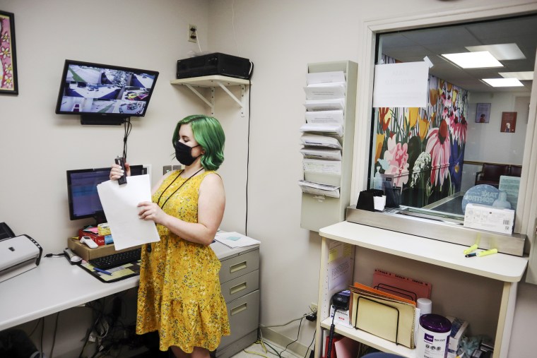 Beth Fiddler, a receptionist and telephone counselor at the Women's Health Center of West Virginia, staples paperwork in her office outside the clinic's empty waiting room on June 29, 2022 in Charleston.