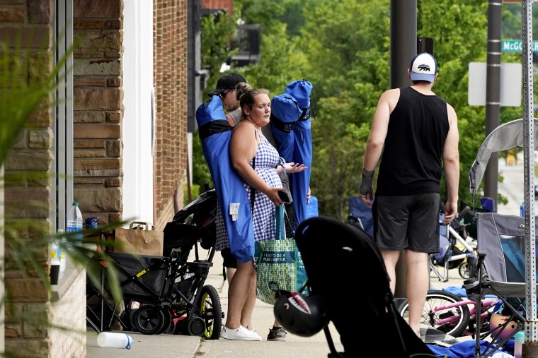 People check their belongings after a mass shooting at the Highland Park Fourth of July parade