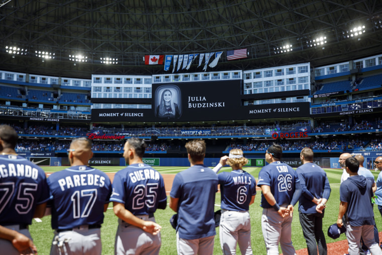 The Tampa Bay Rays players and staff stand for a moment of silence following the death of Julia Budzinski