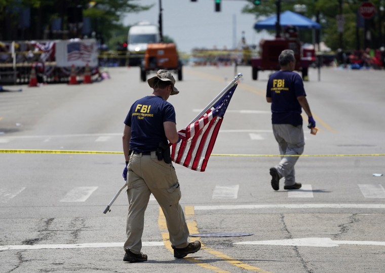 Image: Members of the FBI's evidence response team investigate the scene of a mass shooting in Highland Park, Ill., on July 5, 2022.