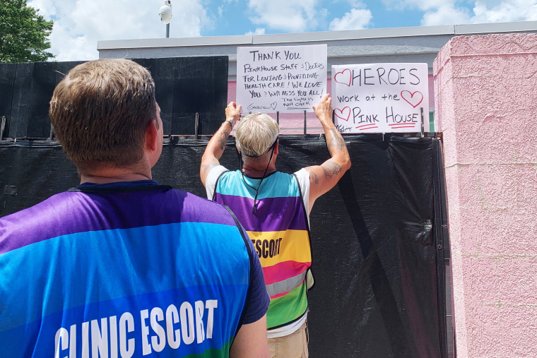 Image: Dale Gibson affixes a sign to the iron fence surrounding the  Jackson Women’s Health Organization clinic on Wednesday.