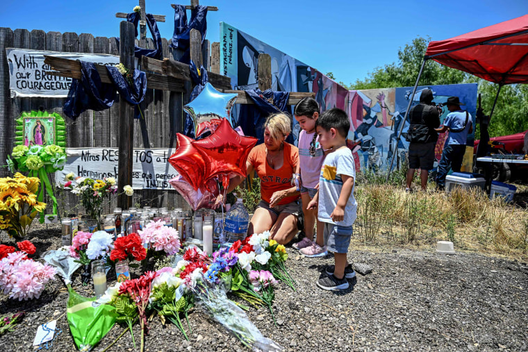 People visit a memorial on June 29, 2022 at the spot where a trailer was discovered with migrants inside