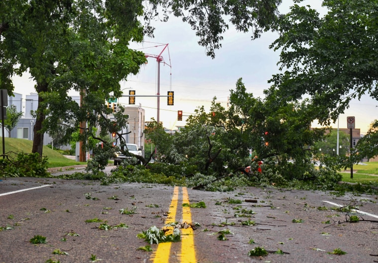 A tree limb lies in the middle of Main Avenue after a storm on July 5, 2022, in Sioux Falls, S.D.