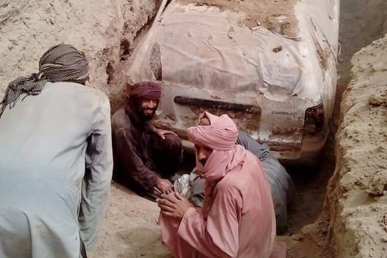 Taliban soldiers dig up a Toyota used by Mullah Mohammad Omar that was buried in 2001 during the start of the U.S.-led invasion of Afghanistan. 
