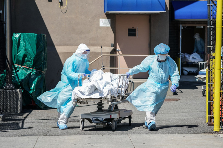 Bodies are moved to a refrigeration truck serving as a temporary morgue at Wyckoff Hospital in Brooklyn, N.Y., on April 6, 2020.