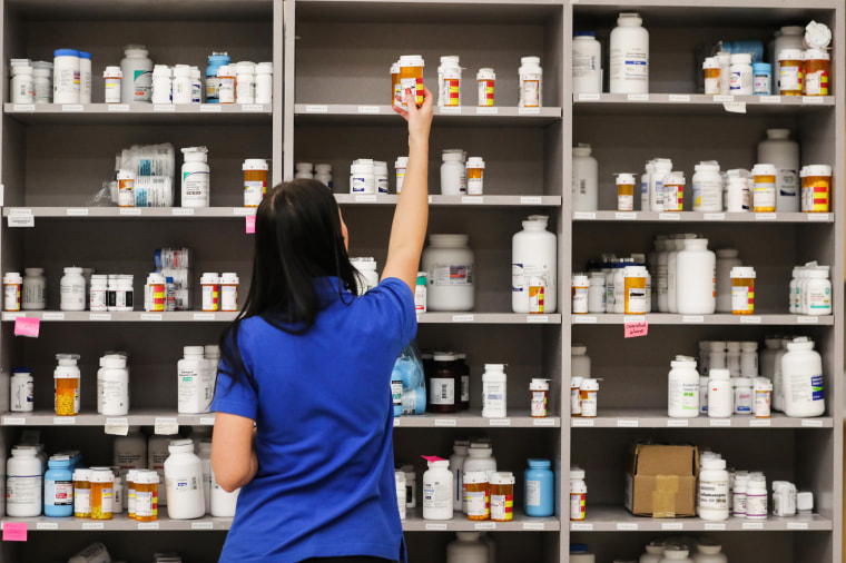 A pharmacy technician grabs a bottle of drugs off a shelf on Sept. 10, 2018, in Midvale, Utah.