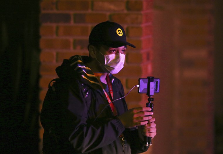 A local resident shoots video of a deadly shooting scene involving Phoenix Police officers in Phoenix, Ariz., on March 29, 2020.