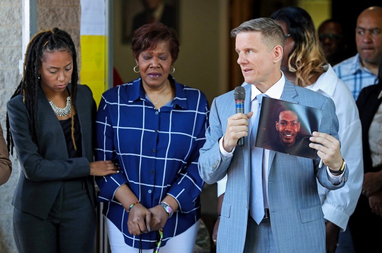 Attorney Bobby DiCello, right, holds up a photograph of Jayland Walker as Paige White, left, comforts Jayland's mother, Pamela Walker, during a press conference at St. Ashworth Temple in Akron, Ohio, on June 30.