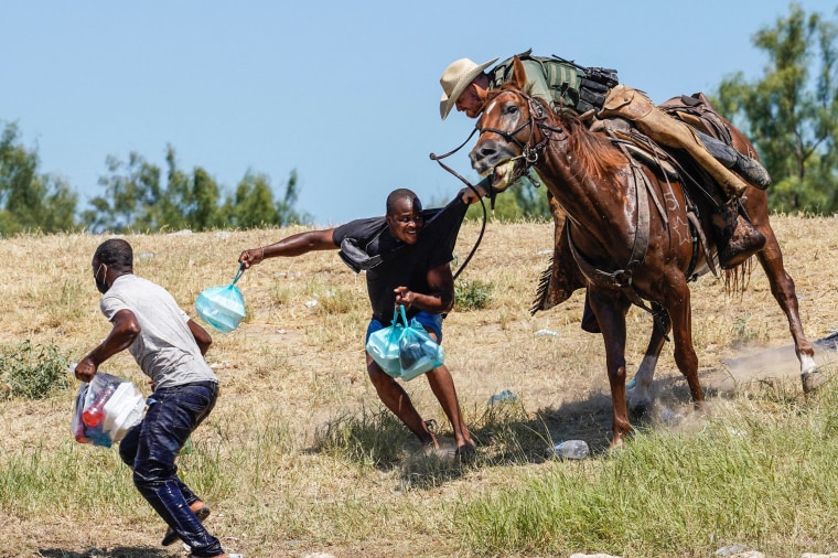 A border patrol agent on horseback tries to stop a Haitian migrant