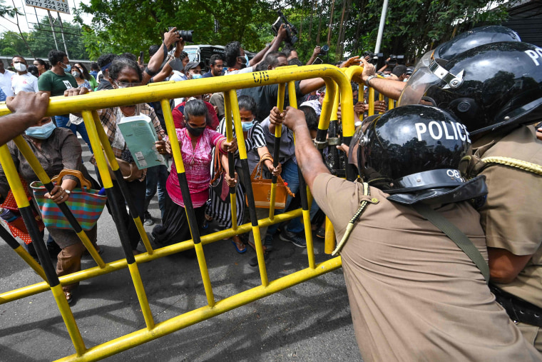 Activists from Samagi Vanitha Balawegaya try to overturn a police barricade