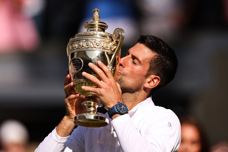 Novak Djokovic kisses the trophy following his victory against Nick Kyrgios at Wimbledon on July 10, 2022, in London.