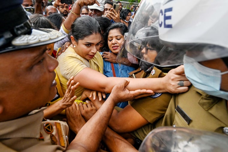 Former member of parliament Hirunika Premachandra, a politician and a leader of Samagi Vanitha Balawegaya, tries to jump over the barriers during a protest outside Sri Lanka's Prime Minister Ranil Wickremesinghe's private residence in Colombo on June 22.